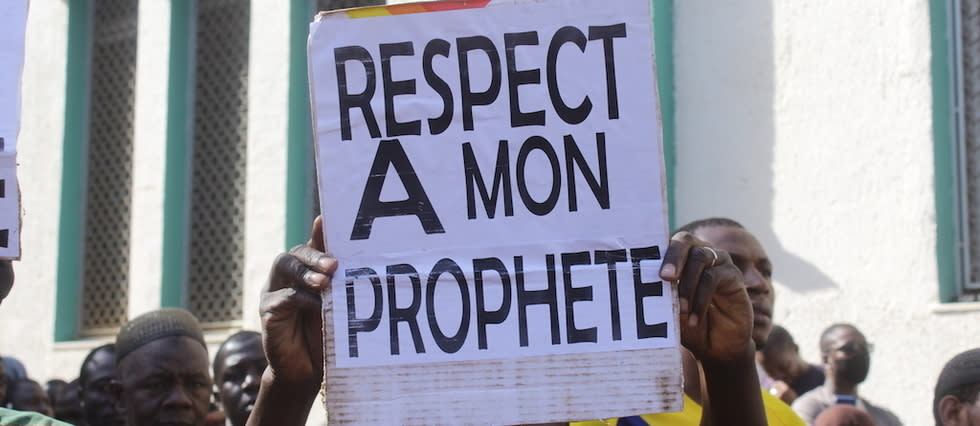 Un homme brandit une pancarte indiquant « Respectez mon prophète » lors d'un rassemblement devant la Grande Mosquée de Bamako le 28 octobre 2020.
