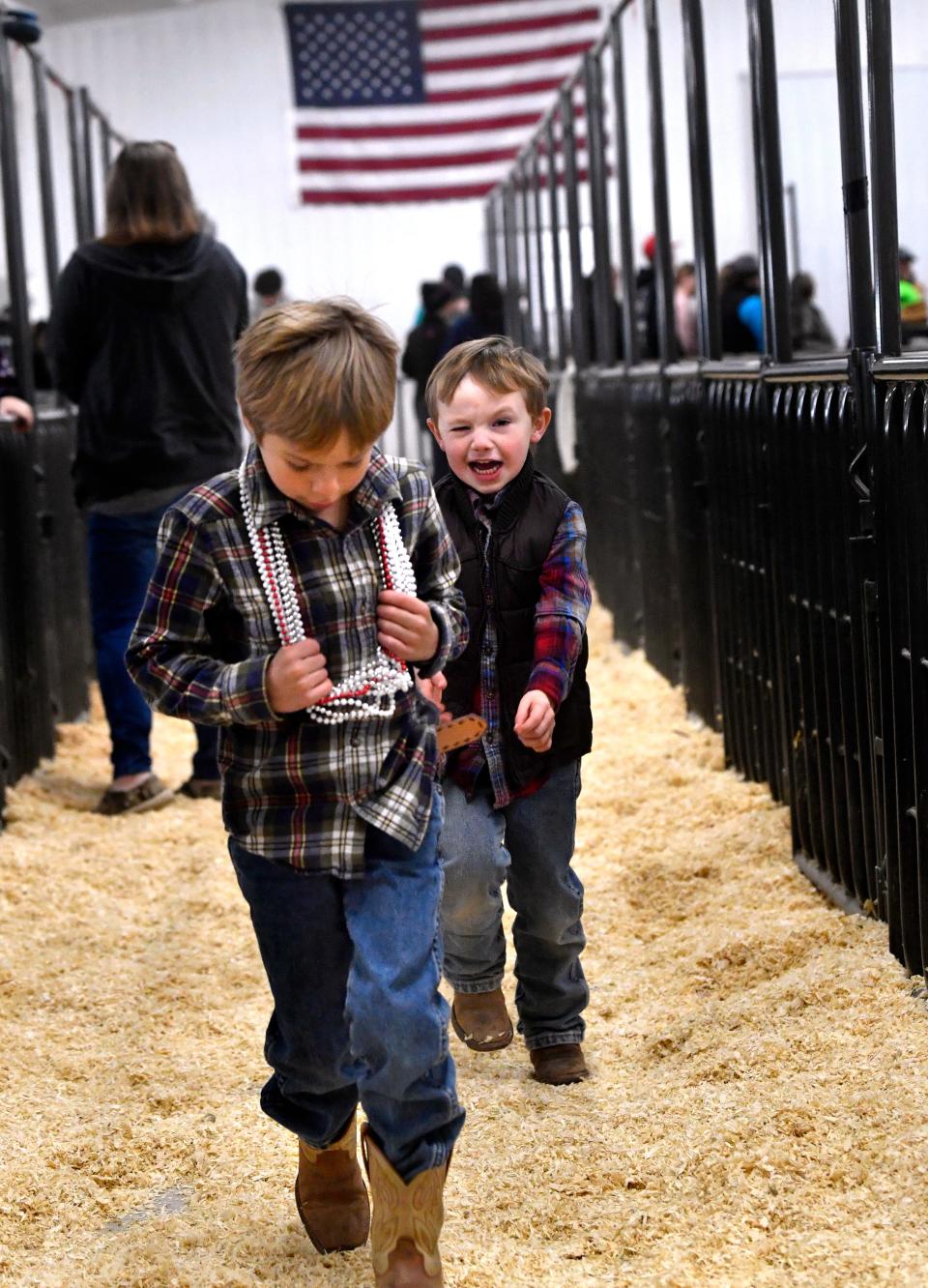 Tres Besner, 6, is chased by his four-year-old brother down the stock pen alleys as the sale goes on in the next room at the Shackleford County Youth & Livestock Show in Albany Jan. 20.