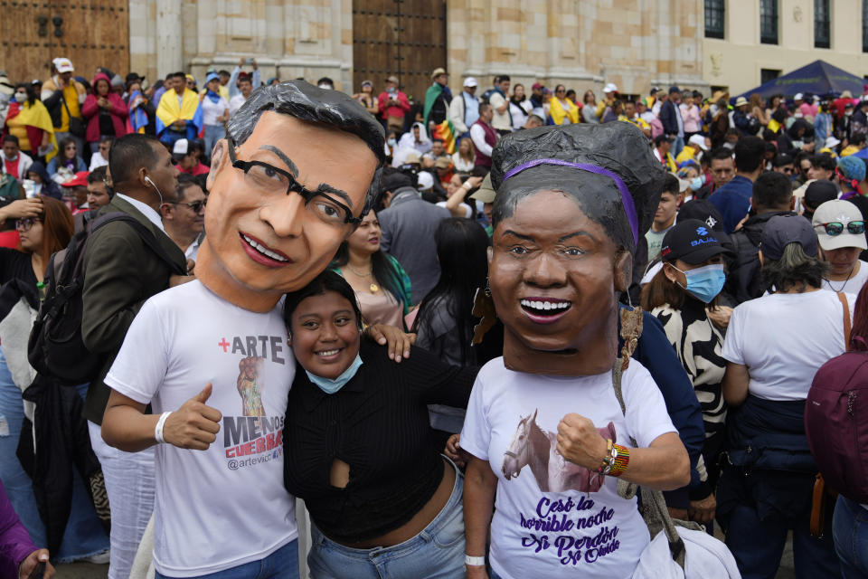 Supporters of new President Gustavo Petro, wearing masks of him and new Vice-President Francia Marquez, right, wait for their swearing-in ceremony at the Bolivar square in Bogota, Colombia, Sunday, Aug. 7, 2022. (AP Photo/Ariana Cubillos)