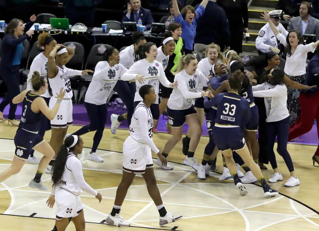 Notre Dame’s Arike Ogunbowale is mobbed by teammates after sinking a 3-point basket to defeat Mississippi State 61-58 in the final of the women’s NCAA Final Four college basketball tournament, Sunday, April 1, 2018, in Columbus, Ohio. (AP Photo/Tony Dejak)