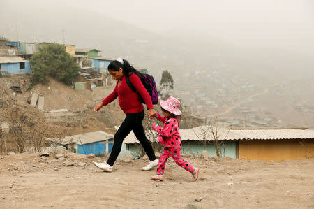 A woman and a child walk on a street in Nueva Union shantytown in Villa Maria del Triunfo district of Lima, Peru, May 25, 2018. REUTERS/Mariana Bazo