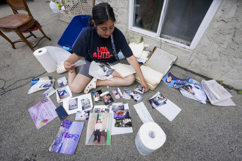 Nelis Gramao dries out her family's photo album while cleaning out her flood damaged home, Friday, Sept. 3, 2021, in Mamaroneck, N.Y. More than three days after the hurricane blew ashore in Louisiana, Ida's rainy remains hit the Northeast with stunning fury on Wednesday and Thursday, submerging cars, swamping subway stations and basement apartments and drowning scores of people in five states. (AP Photo/Mary Altaffer)