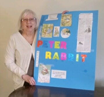Art of Gardening member Claudia Dunn, holding a Peter Rabbit poster, gave a program on planning a garden.