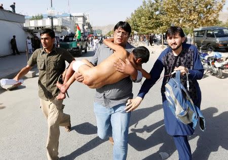 Men carry an injured boy outside a hospital after a suicide attack in Kabul, Afghanistan July 23, 2016. REUTERS/Mohammad Ismail
