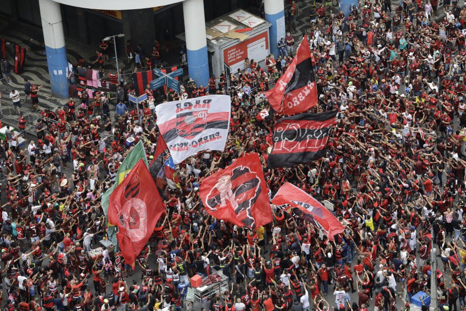 Fans of Brazil's Flamengo cheer as they wait for their arrival in Rio de Janeiro, Brazil, Sunday, Nov. 24, 2019. Flamengo overcame Argentina's River Plate 2-1 in the Copa Libertadores final match on Saturday in Lima to win its second South American title. (AP Photo/Silvia Izquierdo)