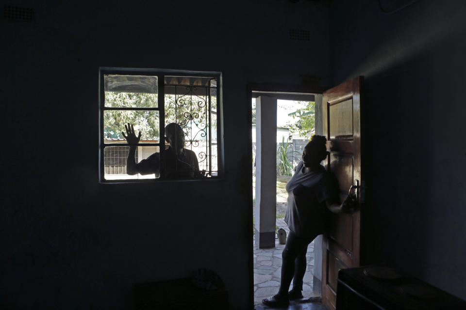 Andrew Ngwenya, left, and his wife, De-egma, are seen at their home in a working class township in Harare, the capital Zimbabwe, on Monday, July, 12, 2021. Ngwenya and his wife went to a hospital that sometimes had spare doses of the COVID-19 vaccine, only to be turned away due to shortages. (AP Photo/Tsvangirayi Mukwazhi)