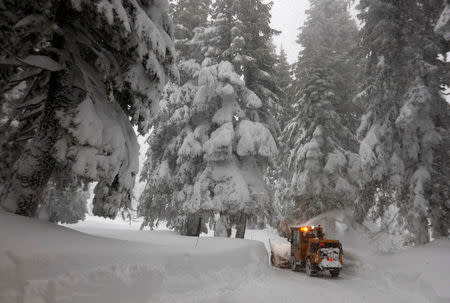 A private contractor clears deep snow from a driveway during a heavy winter storm in Incline Village, Nevada, U.S. January 10, 2017 REUTERS/Bob Strong