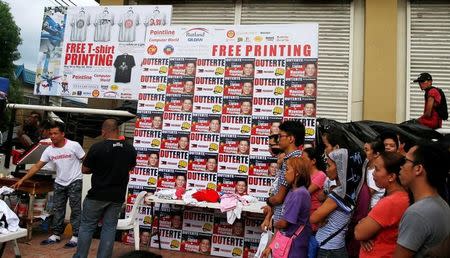 Supporters of presidential candidate Rodrigo "Digong" Duterte queue for campaign shirts a day before the election, in Davao city in southern Philippines May 8, 2016. REUTERS/Erik De Castro