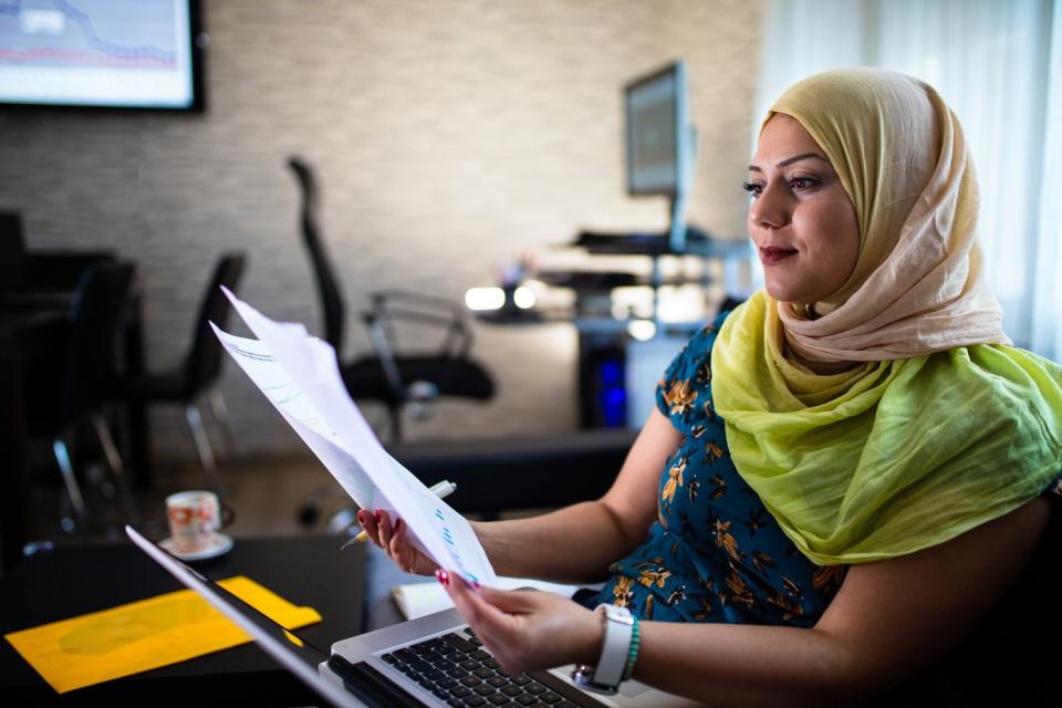 Person studying documents in office.