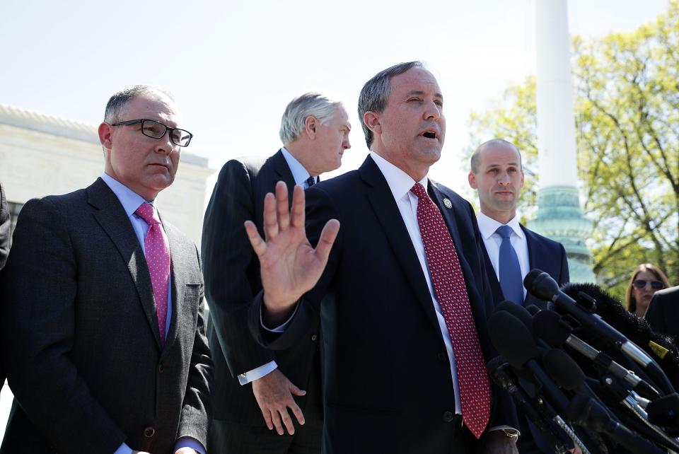 Texas Attorney General Kenneth Paxton speaks to members of the media as Texas Solicitor General Scott Keller (R) listens in front of the Supreme Court April 18, 2016.