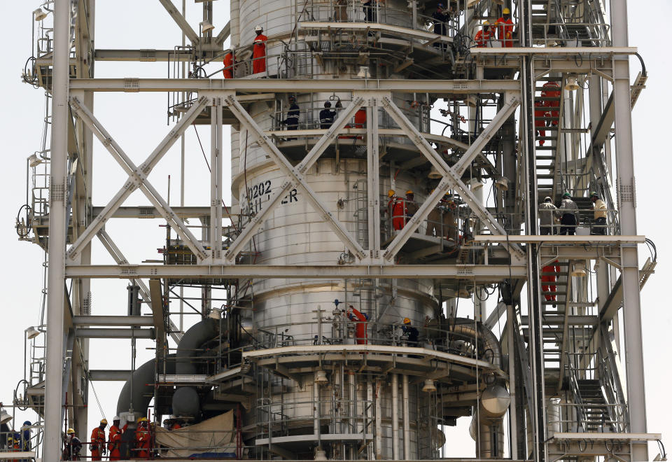 In this photo opportunity during a trip organized by Saudi information ministry, workers fix the damage in the Aramco's Khurais oil field, Saudi Arabia, Friday, Sept. 20, 2019, after it was hit during Sept. 14 attack. Saudi officials brought journalists Friday to see the damage done in an attack the U.S. alleges Iran carried out. (AP Photo/Amr Nabil)