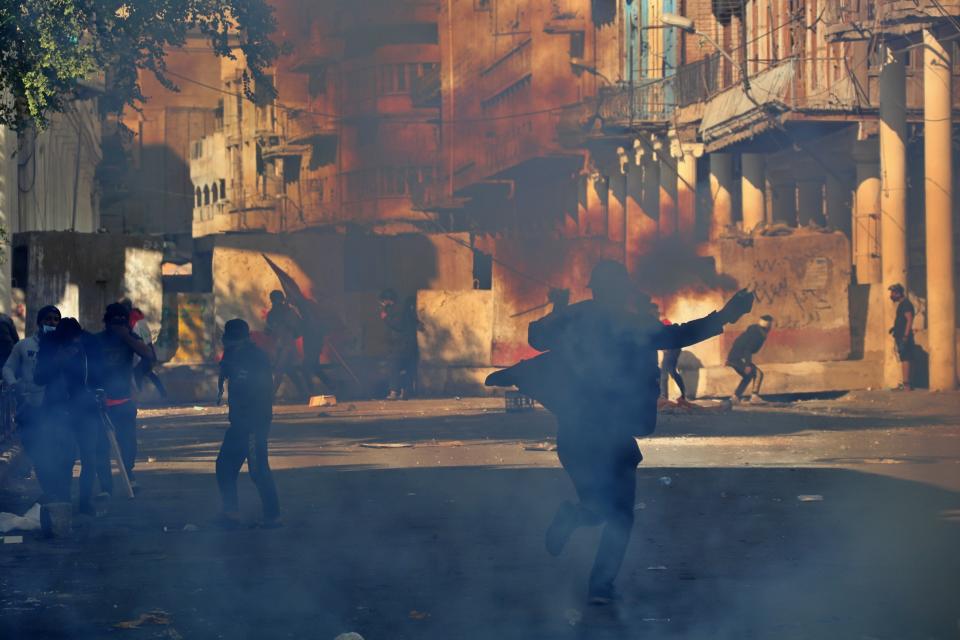 Riot police fire tear gas while blocking al-Rashid Street during clashes with anti-government demonstrators in Baghdad, Iraq, Friday, Nov. 22, 2019. Iraq's massive anti-government protest movement erupted Oct. 1 and quickly escalated into calls to sweep aside Iraq's sectarian system. Protesters occupy several Baghdad squares and parts of three bridges in a standoff with security forces. (AP Photo/Hadi Mizban)