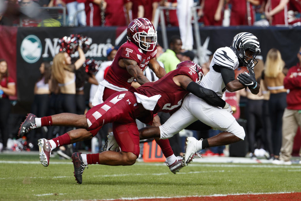 Memphis running back Kylan Watkins (17) runs the ball on his way to a touchdown as Temple linebacker Chapelle Russell (3) and cornerback Christian Braswell (14) try to stop him during the second half of an NCAA college football, Saturday, Oct. 12, 2019, in Philadelphia. Temple won 30-28. (AP Photo/Chris Szagola)