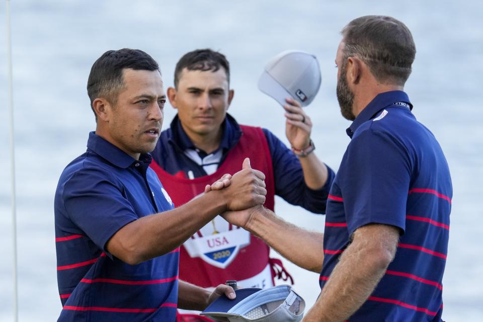 Team USA's Xander Schauffele and Team USA's Dustin Johnson shake hands after winning their four-ball match the Ryder Cup at the Whistling Straits Golf Course Friday, Sept. 24, 2021, in Sheboygan, Wis. (AP Photo/Ashley Landis)
