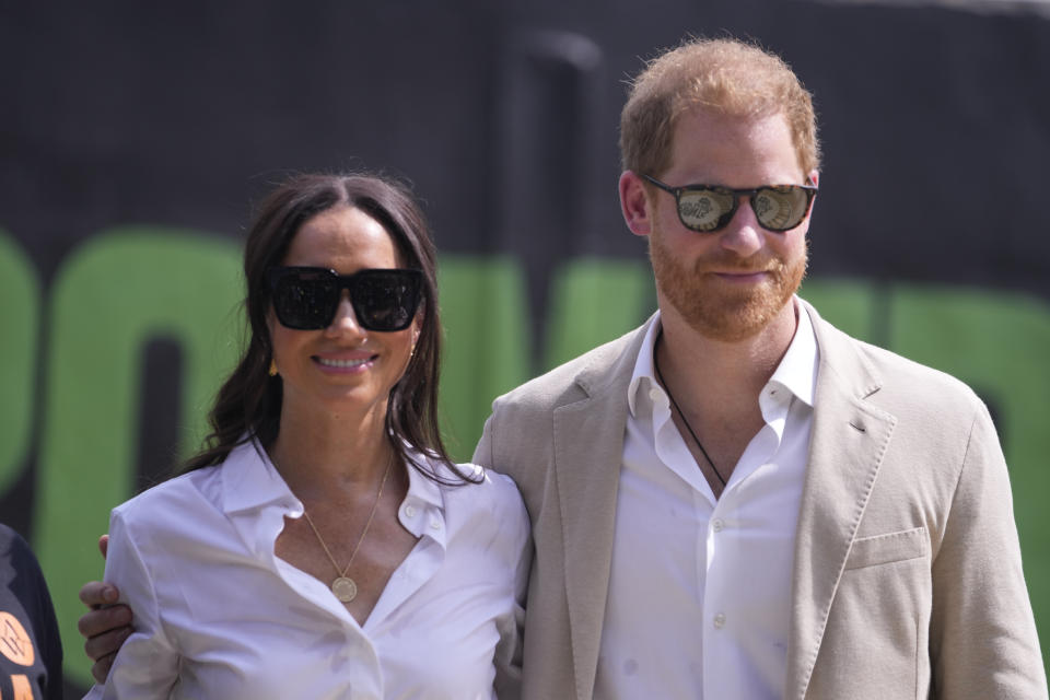 Prince Harry, right, and Meghan, left, attend the Giant of Africa Foundation at the Dream Big Basketball clinic in Lagos Nigeria, Sunday, May 12, 2024. Prince Harry and his wife Meghan are in Nigeria to champion the Invictus Games, which Prince Harry founded to aid the rehabilitation of wounded and sick servicemembers and veterans. (AP Photo/Sunday Alamba)