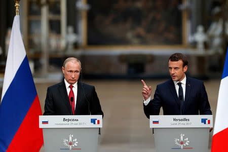 French President Emmanuel Macron (R) and Russian President Vladimir Putin (L) give a joint press conference at the Chateau de Versailles before the opening of an exhibition marking 300 years of diplomatic ties between the two countries in Versailles, France, May 29, 2017. REUTERS/Philippe Wojazer