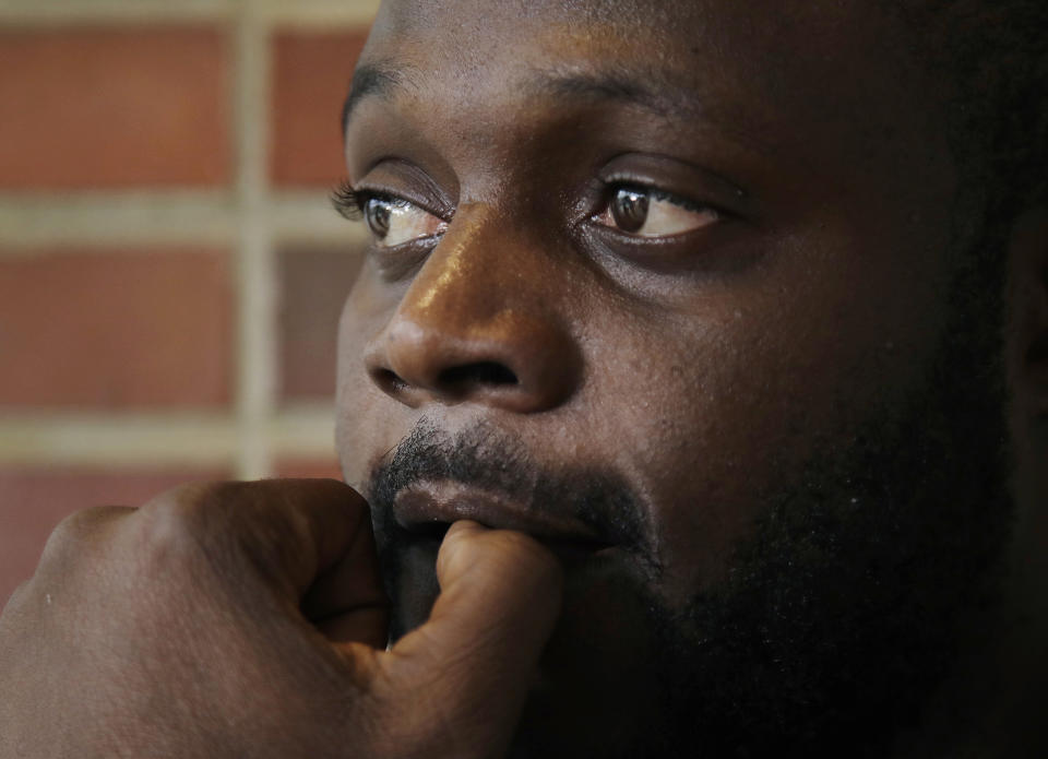 In this June 21, 2019, photo, Blaise Matshieba Nduluyele pauses as he speaks outside the Expo Center in Portland, Maine, about the dangerous journey he and his family made in order to seek asylum in the United States. He and his family have been provided temporary shelter in Portland along with hundreds of other African migrants, mostly from Congo and Angola. (AP Photo/Elise Amendola)