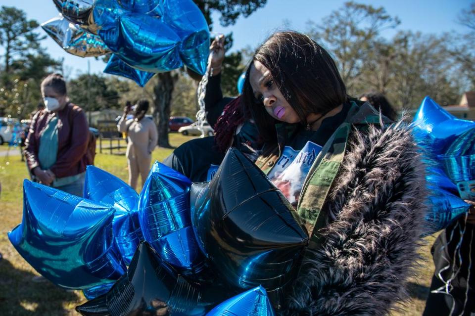 Antonique Faulks, 29, of Moss Point, right, comforts Ashley Watson, 33, of Moss Point, center, during a balloon release in honor of their friend Corri Howard on Monday, Jan. 17, 2022.
