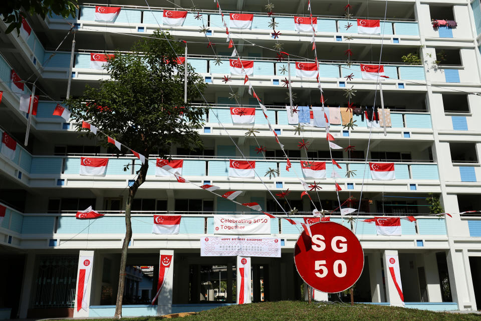 SINGAPORE - JULY 22:  Rows of Singapore national flags and SG50 decorations are put up on an apartment block on July 22, 2015 in Singapore. Singapore will be celebrating her fiftieth birthday on August 9, 2015.  (Photo by Lionel Ng/Getty Images)