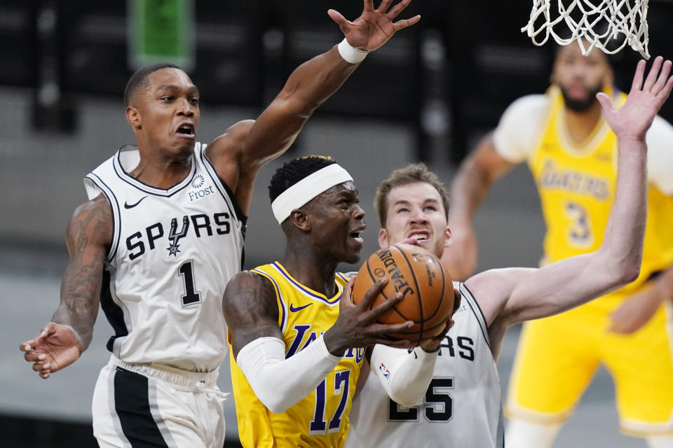 Los Angeles Lakers guard Dennis Schroeder (17) drives to the basket past San Antonio Spurs guard Lonnie Walker IV (1) and center Jakob Poeltl (25) during the second half of an NBA basketball game in San Antonio, Wednesday, Dec. 30, 2020. (AP Photo/Eric Gay)