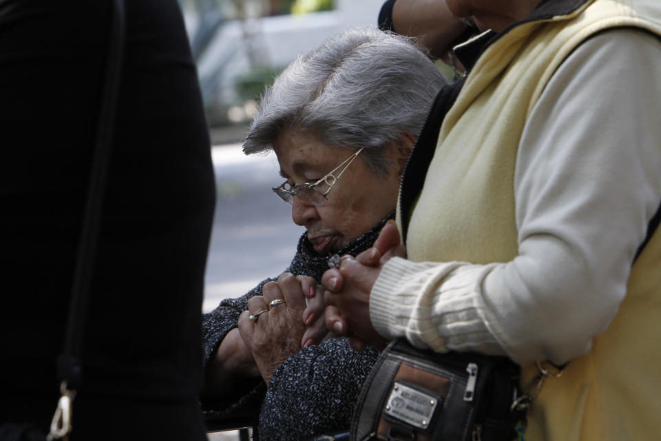 Varias personas que participaban en una procesión por el Viernes Santo se detuvieron a orar tras el terremoto de magnitud 7,2 que afectó la Ciudad de México el viernes 18 de abril de 2014. (Foto AP/Marco Ugarte)