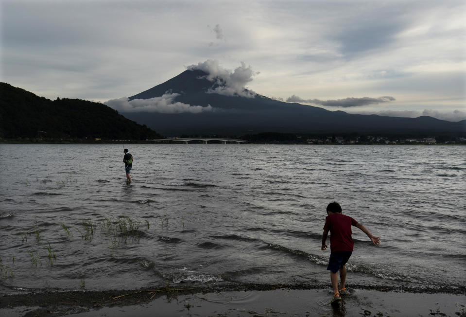Un niño camina por el agua mientras que se ve el Monte Fuji de fondo.<br><br>Foto: AP Photo/Jae C. Hong