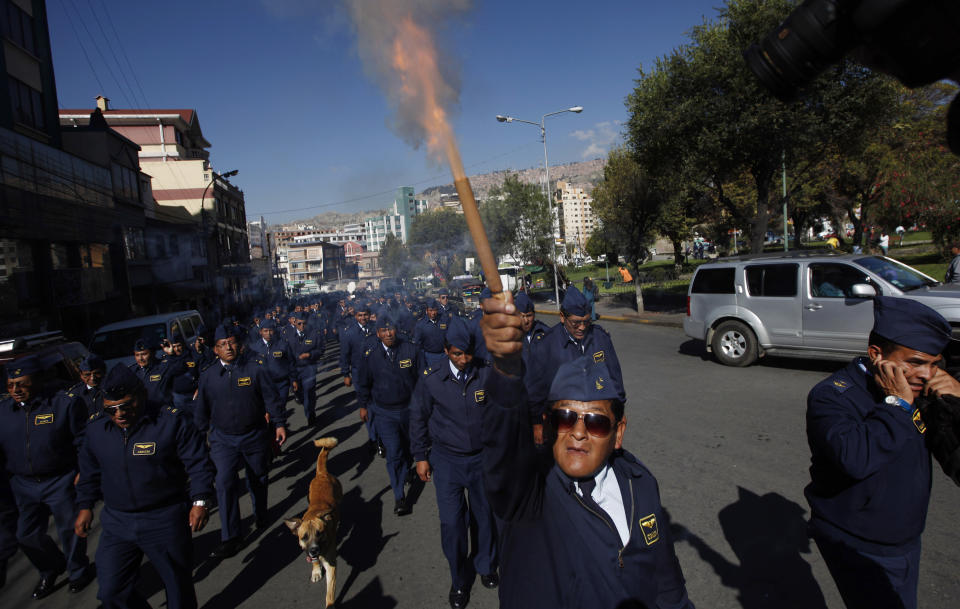 An older member of the Air Force launches a fire cracker during a protest in La Paz, Bolivia, Tuesday, April 22, 2014. Hundreds of low ranking soldiers from Bolivia's Armed Forces marched against the military high command's dismissal of four of its leaders who defended their call for more career opportunities. Soldiers who study three years to be sergeants and then warrant officers want to be given the opportunity to rise in rank, according to Felix Jhonny Gil, president of the National Association of Warrant Officers and Sergeants. The soldiers' wives started a hunger strike in solidarity. (AP Photo/Juan Karita)