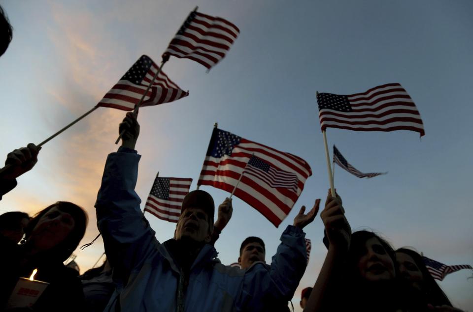 FILE — People, including Barbara J. Cole, center, chant during a vigil for the victims of the Boston Marathon bombing, April 20, 2013, in Watertown, Mass. Ethnic Chechens who lived in Kyrgyzstan and Russia, Tamerlan and Dzhokhar Tsarnaev became radicalized after moving to the United States as teenagers. They built a pair of pressure-cooker bombs, filling them with nails and other metal debris items to cause maximum injury, and set them among the crowd of spectators on Boylston Street. (AP Photo/Julio Cortez, File)