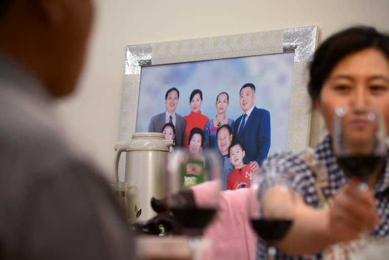 A family photo is seen on the wall at Li Na's home in Beijing, on May 12, 2013. With two cars, foreign holidays and a cook for their apartment, Li's family epitomises the new middle class created by China's decades of rapid economic growth