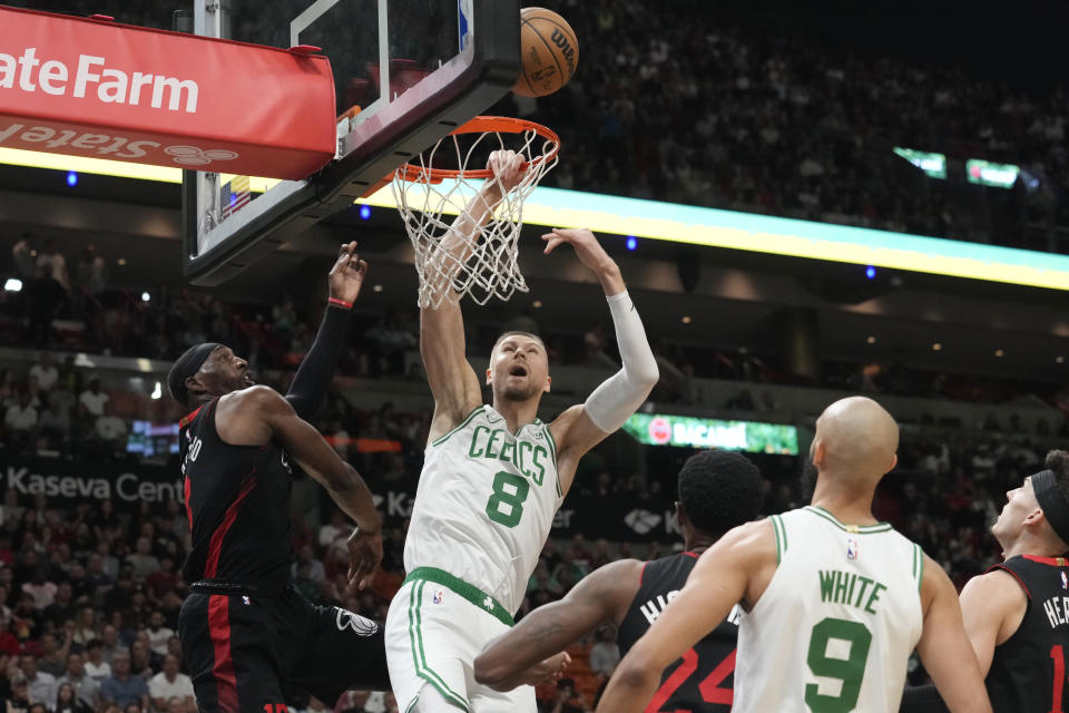 Boston Celtics center Kristaps Porzingis (8) watches as the ball bounces off the net as Miami Heat center Bam Adebayo (13) defends during the first half of an NBA basketball game, Thursday, Jan. 25, 2024, in Miami. (AP Photo/Marta Lavandier)