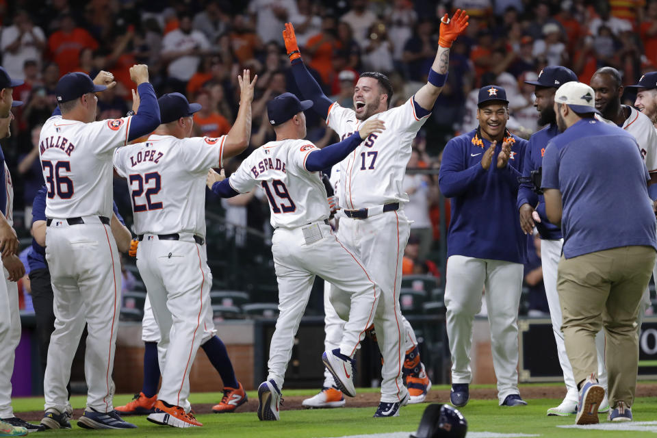 Houston Astros' Victor Caratini (17) celebrates his walk off home run with manager Joe Espada (19) and the rest of the team after defeating the Cleveland Guardians in the 10th inning of a baseball game Tuesday, April 30, 2024, in Houston. (AP Photo/Michael Wyke)
