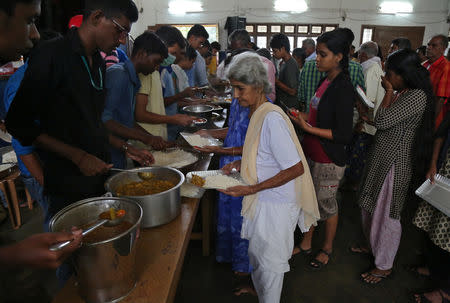 A flood-affected woman receives food inside a college auditorium, which has been converted into a temporary relief camp, in Kochi in the southern state of Kerala, India, August 20, 2018. REUTERS/Sivaram V