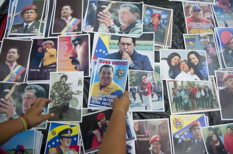 A woman sells pictures of Venezuelan late President Hugo Chavez during a concert organized by groups supporting Venezuelan President Nicolas Maduro in Caracas on April 17, 2013