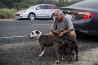 Tiger Wiggles, 57, with his dogs wait to go back home during the Lake Hughes fire in Angeles National Forest on Thursday, Aug. 13, 2020, north of Santa Clarita, Calif. (AP Photo/Ringo H.W. Chiu)