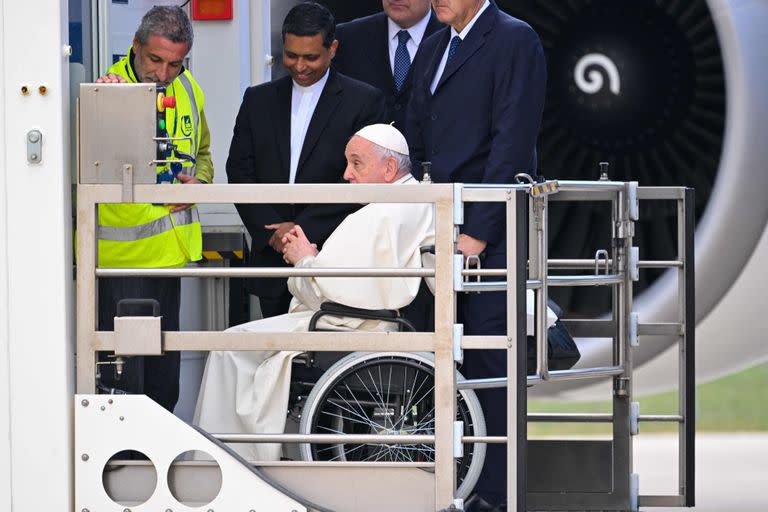 El Papa Francisco, sentado en una silla de ruedas, es elevado en una plataforma para subir a un avión el 3 de noviembre de 2022 en el aeropuerto de Fiumicino de Roma, antes de partir para un viaje de cuatro días a Bahréin