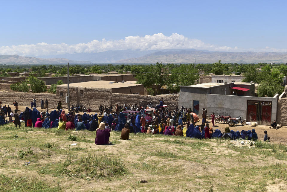 People wait to received foods from residential people after heavy flooding in Baghlan province, in northern Afghanistan Sunday, May 12, 2024. Victims of the devastating floods in northern Afghanistan are burying the dead and looking for the loved ones still missing. (AP Photo)