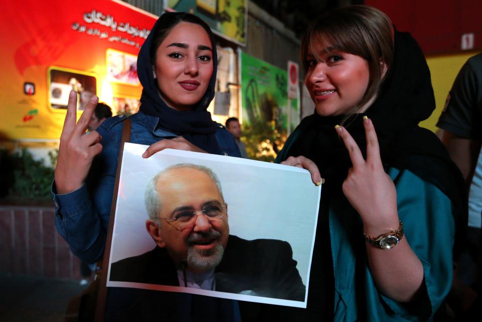 Iranian women hold a portrait of Iranian Foreign Minister Mohammad Javad Zarif and flash the v sign for victory during celebrations in northern Tehran on July 14, 2015, after Iran's nuclear negotiating team struck a deal with world powers in Vienna. 