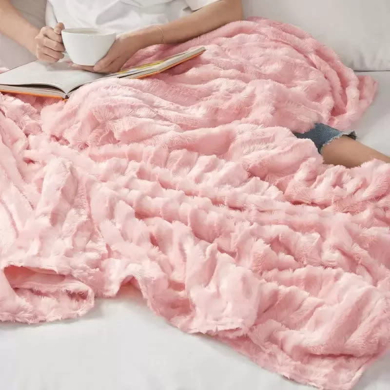 Available in pretty pink and warm gray, this cozy, fuzzy blanket has a removable outer later that's machine-washable. It weighs 18 pounds and measures 60 inches by 70 inches, so it's perfect for sharing or snuggling up with a loved one. Promising review: 