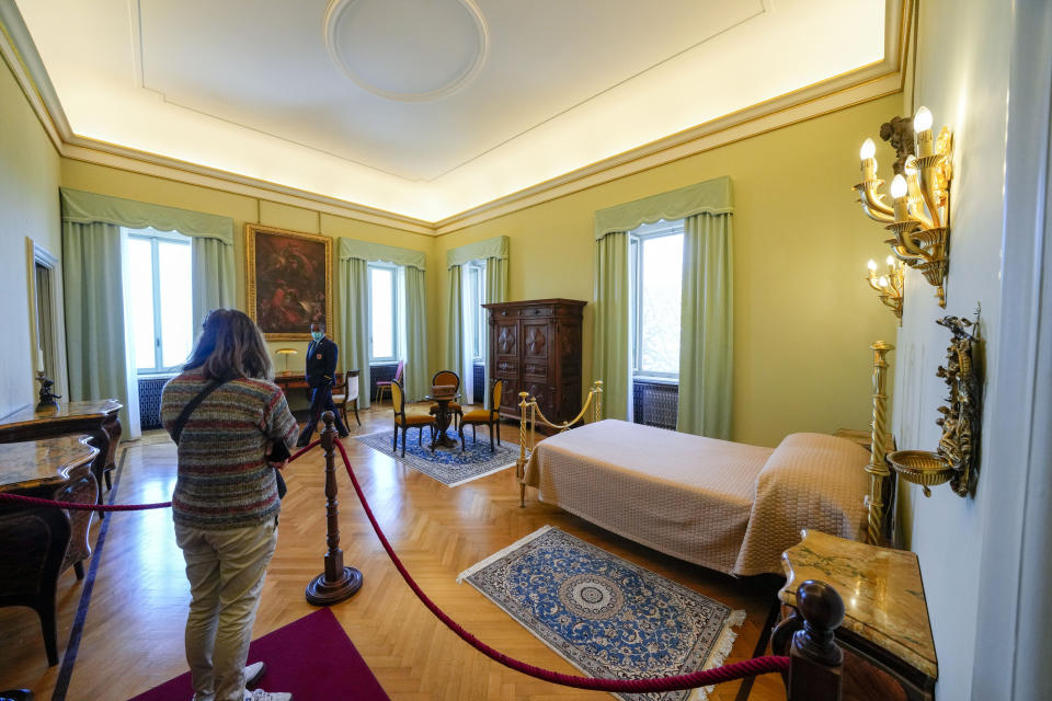 FILE - A visitor looks at the pope's bedroom inside the papal villa in Castel Gandolfo, some 30 kilometers southeast of Rome, May 29, 2021. Pope Emeritus Benedict XVI death has hit Castel Gandolfo's "castellani" particularly hard, since many knew him personally, and in some ways had already bid him an emotional farewell when he uttered his final words as pope from the palace balcony overlooking the town square. (AP Photo/Andrew Medichini, File)