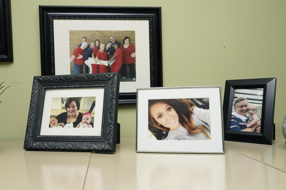 CORRECTS TO DELETE THE MIDDLE NAME AND SAY HARBOUR WAS A VICTIM - Denise Spears has a portrait of her late step-daughter, Marsha Harbour,, second from right, among family and staff photographs displayed in her Meridian, Miss., office, Tuesday, April 12, 2022. Although Marsha's husband, Truitt Pace, admitted killing his wife, he was free on bond while court proceedings were partially held up because the Mississippi Medical Examiner's Office autopsy report was delayed for a year, and the trial got held up further because of the pandemic and other factors. Harbour was a victim of domestic violence. (AP Photo/Rogelio V. Solis)