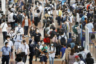 Travelers wearing face masks crowd at Haneda airport in Tokyo Saturday, Sept. 19, 2020, on the first day of the 4-day holiday. (Kyodo News via AP)