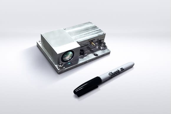 A Strobe lidar unit, a small metal box with a lens on the side, is shown next to a Sharpie marker. The Sharpie is a bit longer than the lidar unit.