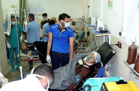 A woman affected by what activists say was a gas attack on the town of Telminnes breathes through an oxygen mask at Bab al-Hawa hospital, where she was transferred to, close to the Turkish border April 21, 2014. REUTERS/Amer Alfaj