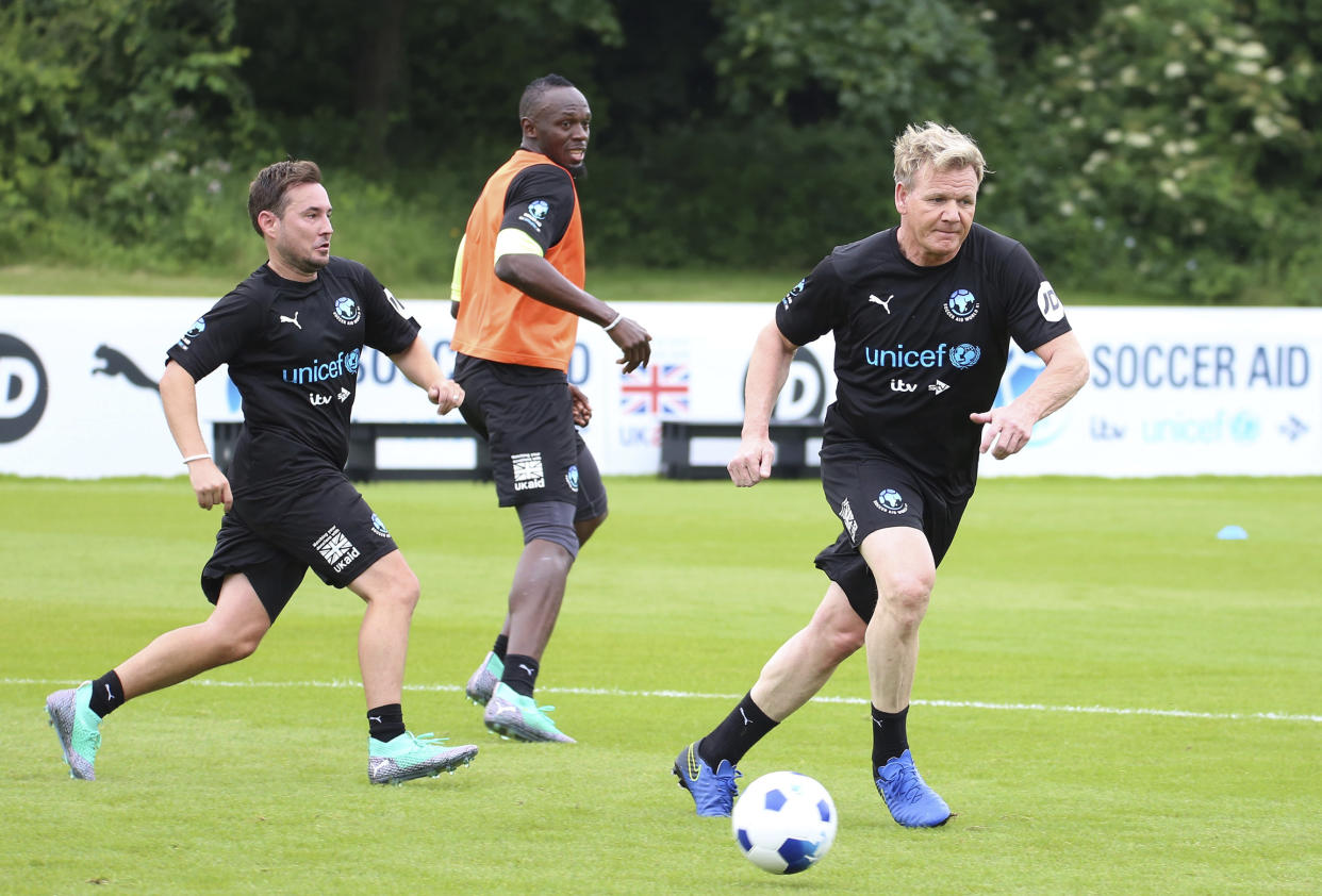 Martin Compston, Usain Bolt and Gordon Ramsay, from left, take part in the  World XI team's training session for Soccer Aid for UNICEF at Motspur Park, in London, Thursday June 7, 2018. (Isabel Infantes/PA via AP)