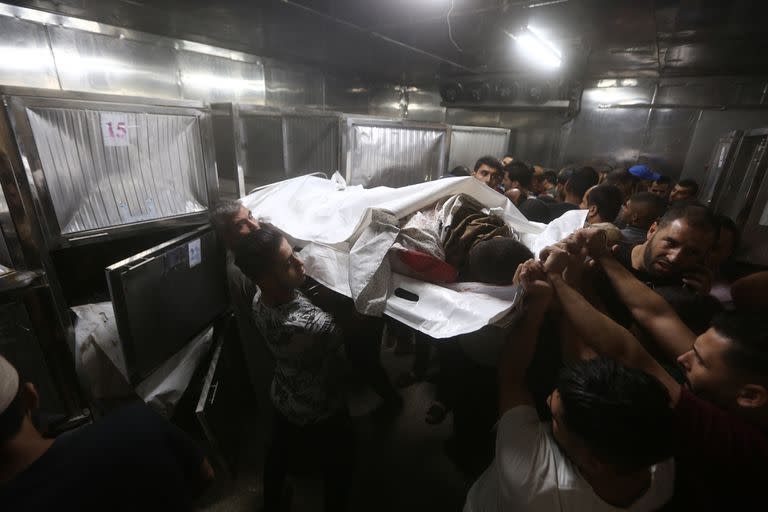 07 October 2023, Palestinian Territories, Gaza City: Mourners carry the bodies of Palestinians killed in the latest infiltration into Israel, inside Shifa Hospital in Gaza City. Several armed Palestinians have entered Israeli territory during the barrage of rocket attacks from the Gaza Strip, according to army sources. Photo: Mohammed Talatene/dpa