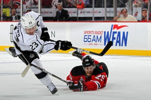 Los Angeles Kings' Dustin Brown (L) fires the puck as New Jersey Devils' Mark Fayne defends during game one of their NHL Stanley Cup Final on May 30. Fayne missed an open shot with little more than 10 minutes remaining