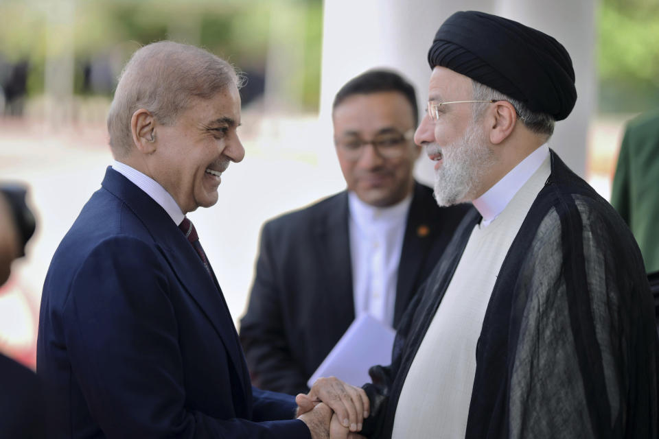 In this photo released by Prime Minister Office, Pakistan's Prime Minister Shehbaz Sharif, left, greets to Iranian President Ebrahim Raisi upon his arrival in the prime minister house in Islamabad, Pakistan, Monday, April 22, 2024. (Prime Minister Office via AP)