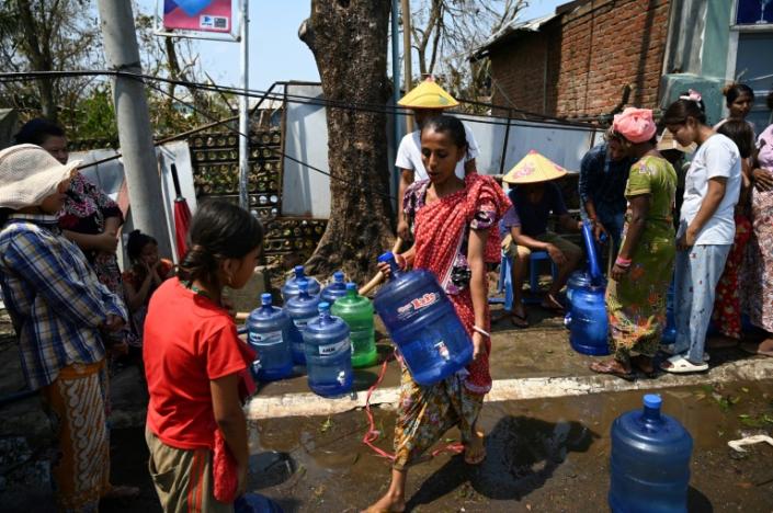 People queue for water and rice in the Rakhine state capital Sittwe while UN officials negotiate with the junta for access after deadly Cyclone Mocha hit Myanmar