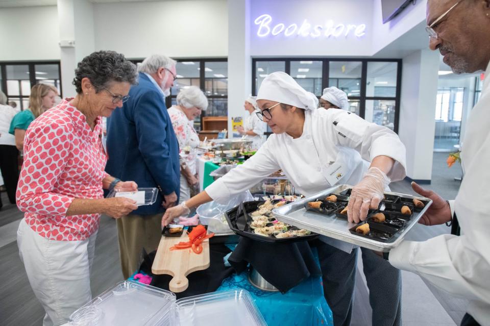 Marla Caras, center, puts out more dishes during the Garde Manger donor appreciation reception in the Molly McGuire School of Culinary Arts and Hospitality Programs at Pensacola State College in Pensacola on Wednesday, July 19, 2023.