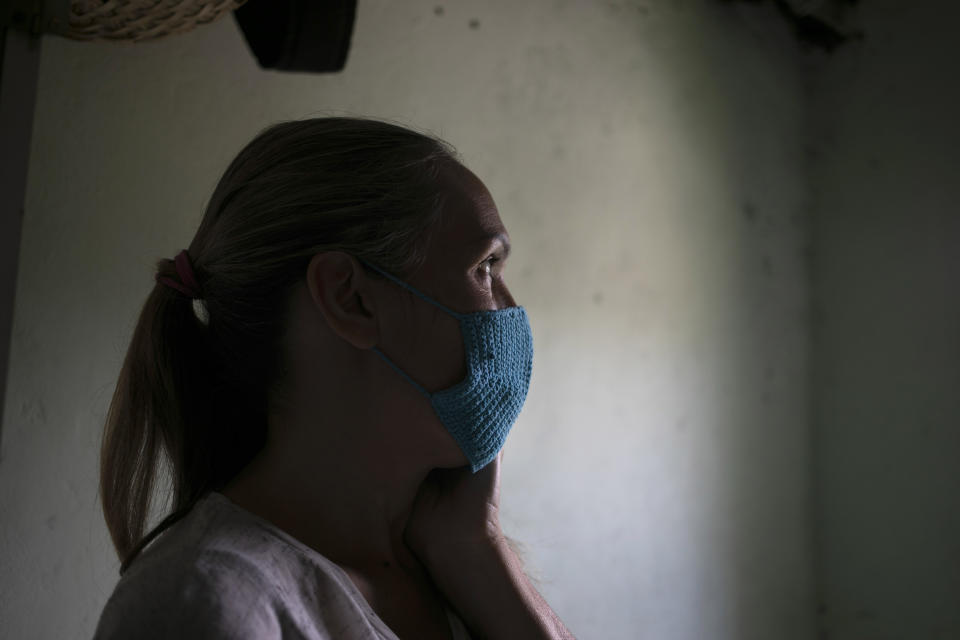 In this April 24, 2020 photo, Maylin Perez sits inside her three-room apartment in Caracas, Venezuela. Perez said she tries to convince her son who is working in Peru not to worry about sending money because she's more concerned about him potentially getting infected with the new coronavirus. “Take care of yourself,” she said tells him. “Your first priority is your health, your life.” (AP Photo/Ariana Cubillos)